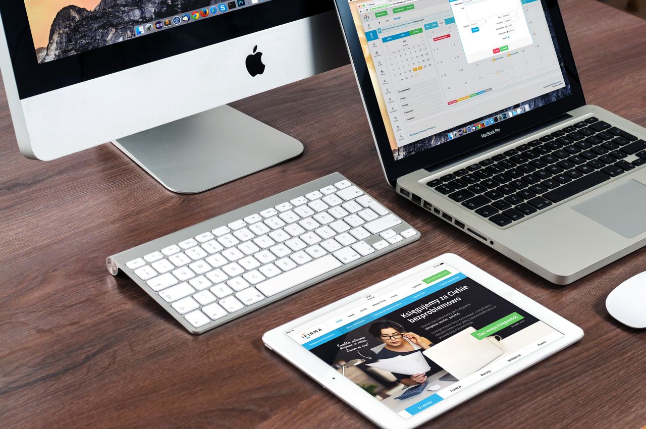 Elegantno uređen uredski stol s Apple uređajima: iMac, MacBook i iPad.